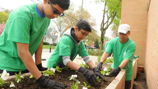 From left, Troop 147 Scouts Anish Kumar, Suvan Bhat, and leader Shree Bhat plant fresh flowers in front of Radcliffe Elementary School on Bloomfield Avenue, during last year's Nutley community clean-up for Project Earth Day.