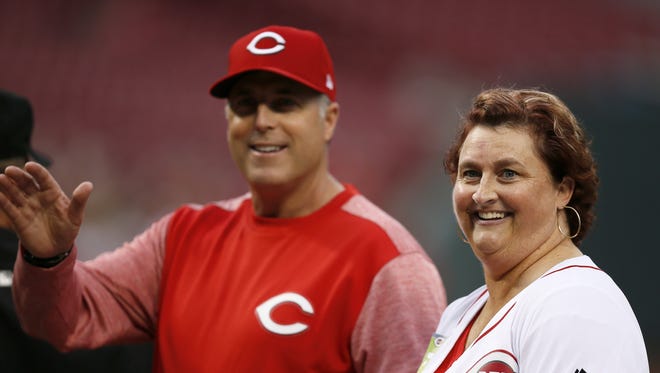 Honorary Captain Kathi VanWinkle and Cincinnati Reds manager Bryan Price (38) deliver the lineups before the first inning of the MLB National League game between the Cincinnati Reds and the Colorado Rockies on Friday, May 19, 2017.
