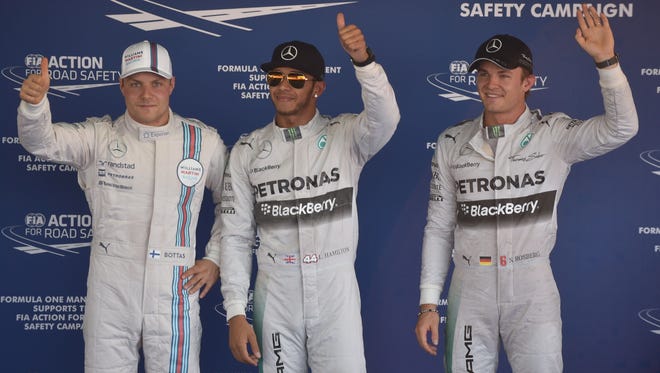 Williams driver Valtteri Bottas, Mercedes driver Lewis Hamilton and Mercedes driver  Nico Rosberg wave after taking top-three positions in the qualifying session of the inaugural Russian Grand Prix at the Sochi Autodrom.