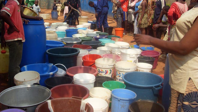 People wait as buckets are filled with water at a distribution point in Yaounde, Cameroon, in 2010. Cameroon has an abundance of freshwater resources, but its water systems are highly fragmented and underfunded, according to a UN report published in 2009.