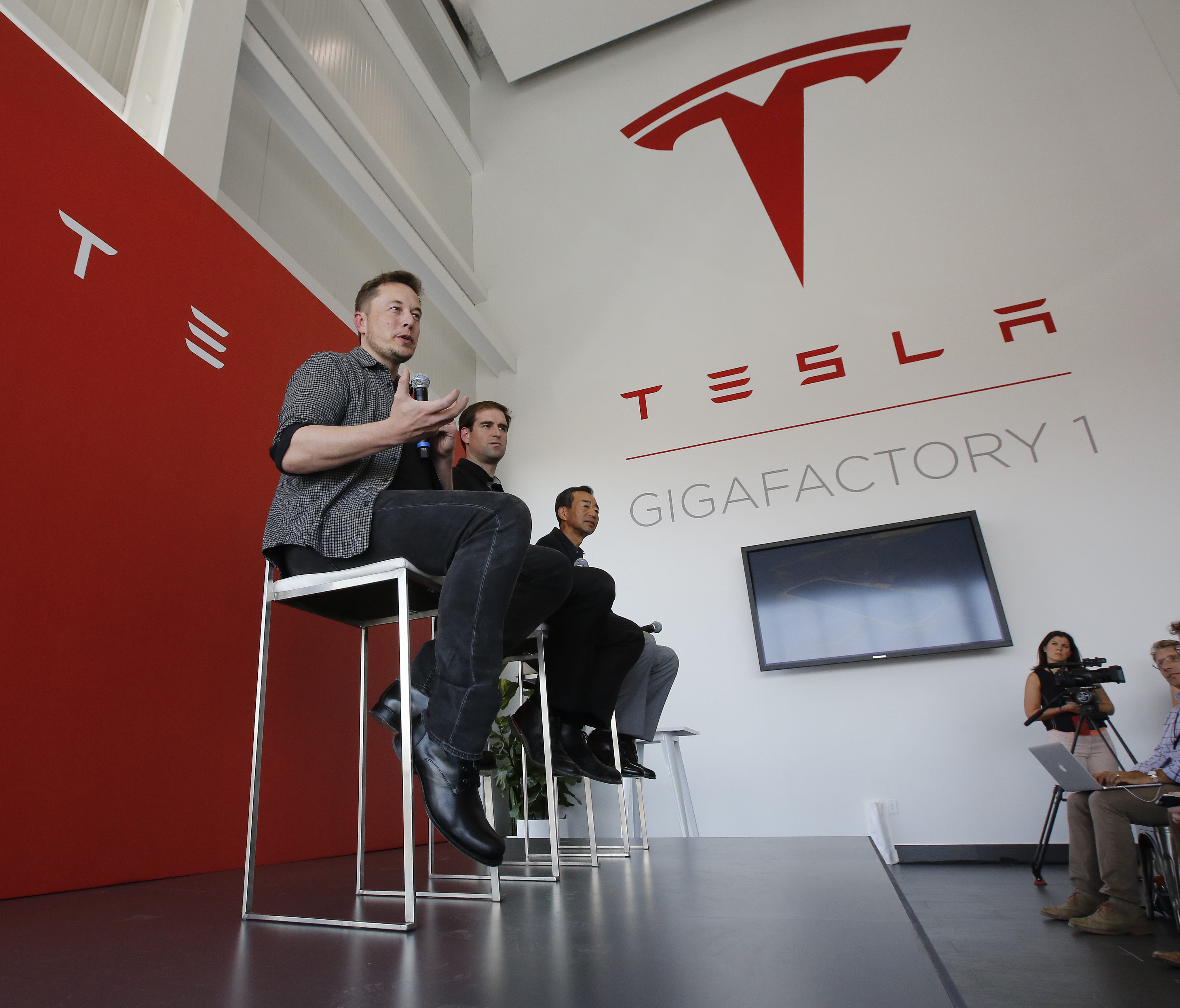 FILE--In this July 26, 2016, file photo, Elon Musk, CEO of Tesla Motors Inc., left, discusses the company's new Gigafactory in Sparks, Nev. Tesla announced Thursday, Sept. 15, 2016, that it had been selected by the utility to construct the battery st