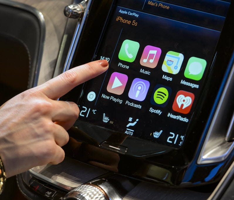 A visitor presses the new Apple's CarPlay touch-screen commands inside the Volvo Estate concept car displayed at the Swedish carmaker during the press day of the Geneva Motor Show in Geneva on March 4, 2014.