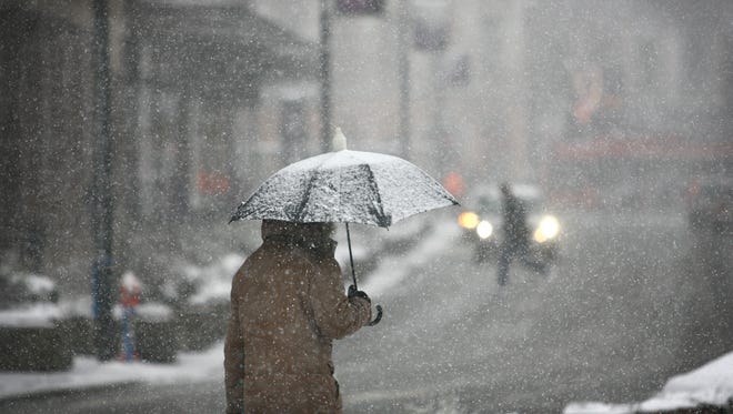 Man with umbrella during snowstorm.