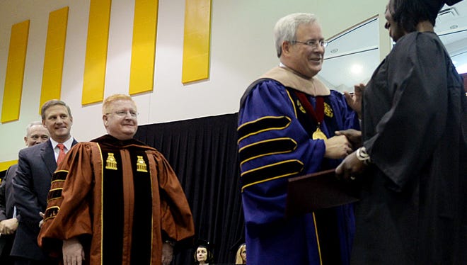 Bossier Parish Community College Chancellor Jim Henderson shakes hands with the recent graduates during the commencement ceremony Friday morning.