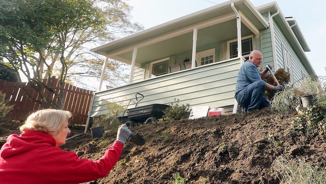 Volunteers Jackie and Bob Fojtik work on the landscaping in front of the Community Frameworks home on Highland Avenue in Bremerton.