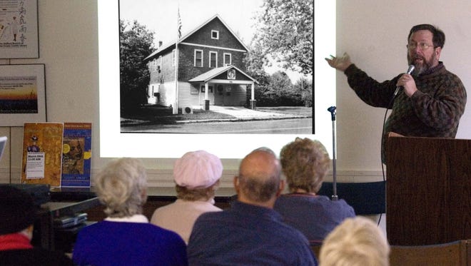 FILE Tim Hart, director of Tuckerton Seaport, addresses a crowd about Women's Suffrage.  Held at the Ocean County Library Stafford Branch.  Showing an image of 1st Library in Manahawkin.