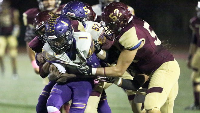 Burges running back Quan McNeil, 1, is swarmed by Andress defenders, including Guillermo Hermosillo 52, Friday night at Andress.