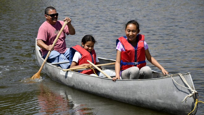 A volunteer helps Richgrove Elementary School students Desiah Saucedo, 10, and Jocelyn Martinez, 11, canoe at Camp Zap on Saturday, May 19, 2018.