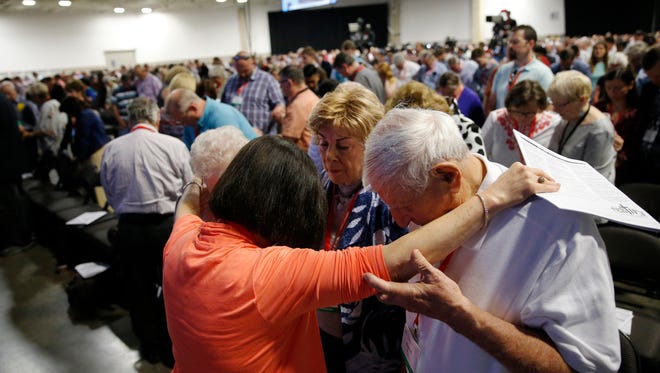 Cindy Boto (bottom left), Peggy Hott, slightly hidden, Pat King-Boto, center facing camera, and August Boto, far right, pray as a group amongst others during a time of prayer at the 2018 Annual Meeting of the Southern Baptist Convention at the Kay Bailey Hutchison Dallas Convention Center in Dallas on Tuesday, June 12, 2018.