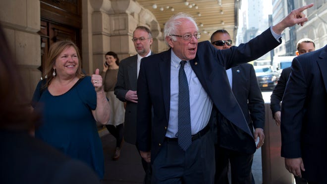 Democratic presidential candidate Sen. Bernie Sanders, I-Vt., and his wife Jane, gesture at supporters as they take a walk in New York's Times Square, Tuesday, April 19, 2016.