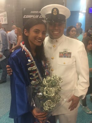 Angela Aleida Madrigal Roman poses with her father, Chief Petty Officer Monseise Madrigal, at her graduation Friday, May 28, 2017, at American Bank Center.