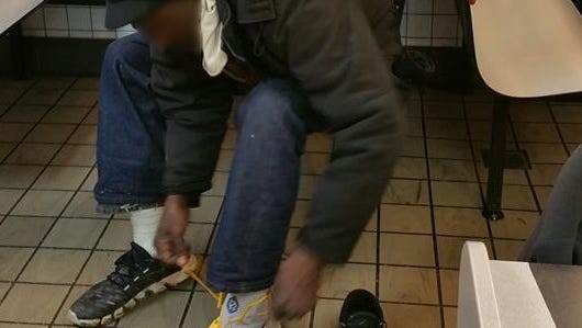 A homeless man puts on size 17 shoes, courtesy of the Lawrence Police Department and Indiana Pacers.