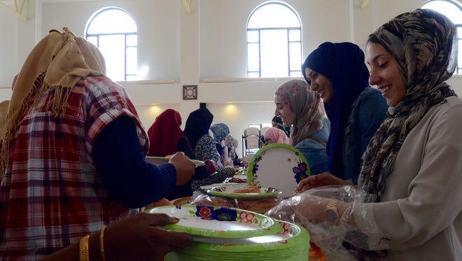 Women line up to eat during a Syrian refugee picnic at Islamic Center of Rochester. Most of the women in this photo are refugees of Syria.
