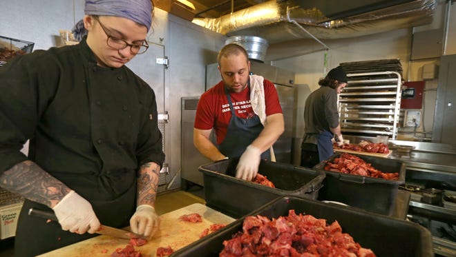The kitchen crew at Good Luck restaurant, Taylor Wilde, Brent Bailey and Sam Wolcott, work to break down and process meat from an entire cow delivered to the restaurant in Rochester Tuesday, March 29, 2016.  The trio are cutting and cubing meat that will be used for hamburger.  The restaurant will use about 350 pounds of ground meat each week for their popular burgers. 