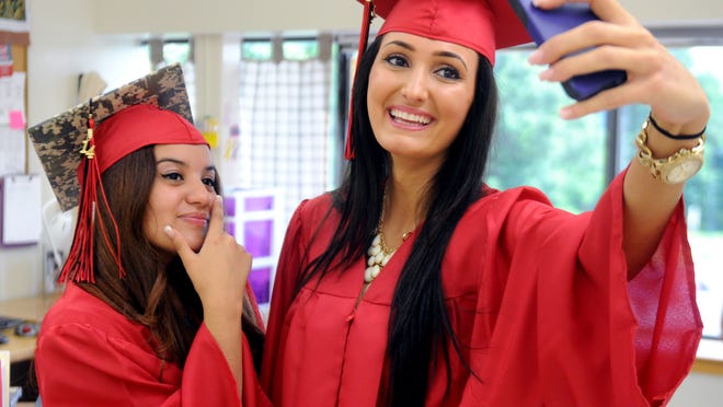 Orchard View Alternative High School graduate Linda Gashi, right, of Fishkill, takes a selfie with fellow graduate and class President Angelica Morales, of Wappingers Falls, on Friday at the Myers Corners Road school.