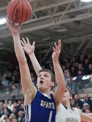 St. Peter's Mason Campbell goes for a layup past St. Mary's Central Catholic's David Miller during the district title game at Willard High School on Friday.