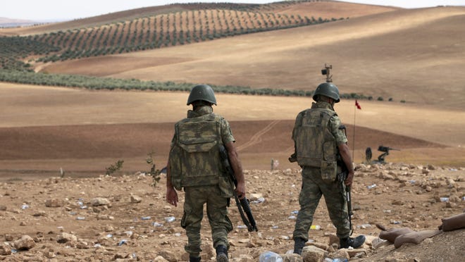 
Turkish soldiers patrol as Islamic militants fight Kurdish forces to the west of Kobani, Syria, at the Turkey-Syria border on Tuesday, Sept. 30, 2014. U.S.-led coalition air strikes have targeted Islamic State fighters, vehicles and weapons on both sides of the Syria-Iraq frontier. 
