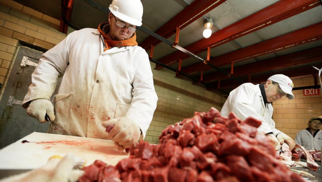 Amend Packing Company worker Chris Jorgensen, left, cuts stew meat, Tuesday, Feb. 17, 2015, in Des Moines, Iowa. Demand for local beef is surging but people who slaughter cattle and slice the beef into steaks say few people want to go into the business. Nationally, there were 1,200 federally inspected livestock slaughterhouses in the U.S. in 1990. By 2010 the number had dropped to 800. (AP Photo/Charlie Neibergall)