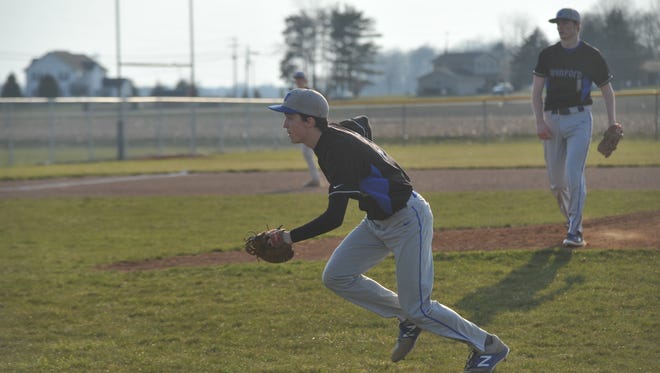 Noah chases down a foul bunt with Wyatt behind him on the mound.