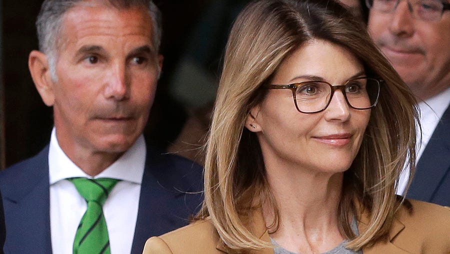 Actress Lori Loughlin, front, and husband, clothing designer Mossimo Giannulli, left, depart federal court in Boston on April 3, 2019, after facing charges in a nationwide college admissions bribery scandal.