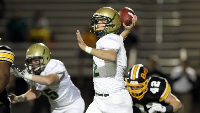 West High quarterback Alex Henderson throws down field during the Trojans' game at Bettendorf on Monday, Nov. 2, 2015.