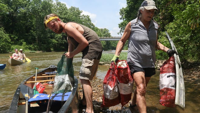Ben Collins of Willard and Josette Coffman of Highlandville remove  trash and tires from a canoe after a five and a half mile trip down the James River after collecting the trash for the James River Basin Partnership's 18th Annual River Rescue Clean-Up on Saturday, June 18, 2016.