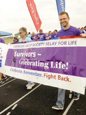 File - From left, Patsy Walesh, Sharon Wondrash and Zach Thorne lead the survivors lap at Two Rivers High School during the Relay for Life of Manitowoc County benefiting the American Cancer Society in 2014.