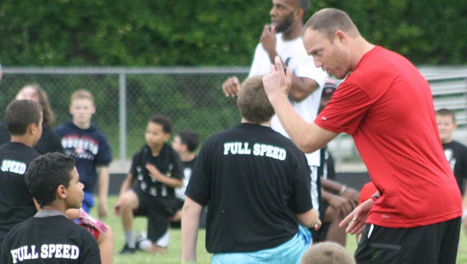 During his 2015 football camp at Clarenceville, 
Tim Shaw demonstrates proper technique to one of the campers. Despite being slowed by ALS, Shaw continues to host the camp.