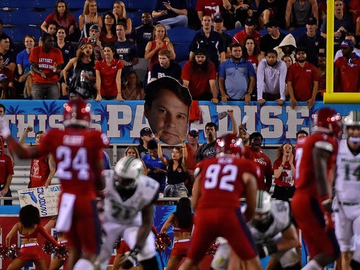 Florida Atlantic fans hold up a big head likeness of