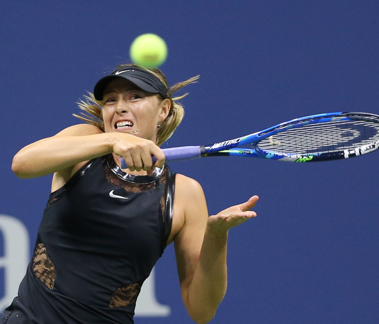 Maria Sharapova, of Russia, returns a shot to Simona Halep, of Romania, on day one of the U.S. Open tennis tournament at USTA Billie Jean King National Tennis Center in New York.