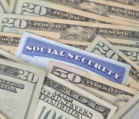 a social security card nestled among us currency bills