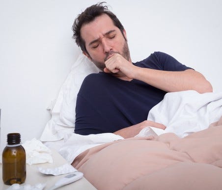 Man sick in bed, coughing