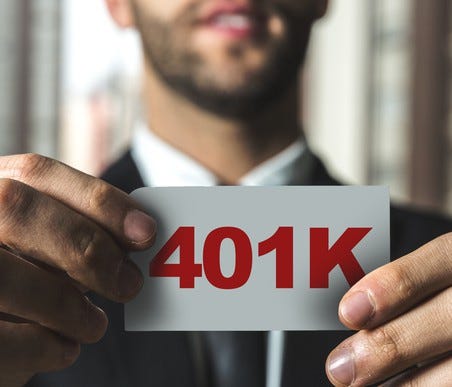 Man holding a white piece of paper that says 401K in red letters