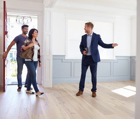 Couple looking at an empty home with a real estate agent