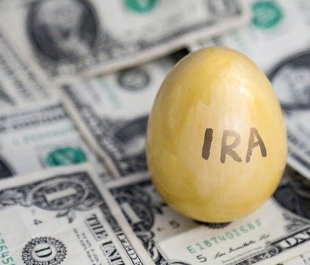 Golden egg with IRA written on it on top of cash