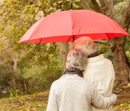 Senior couple outdoors under an umbrella