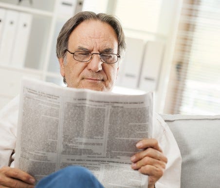 Older man reading a newspaper