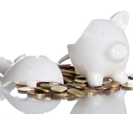 Broken piggy bank with coins falling out