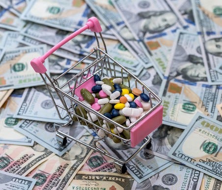 Pills in a toy shopping basket on top of a pile of money.