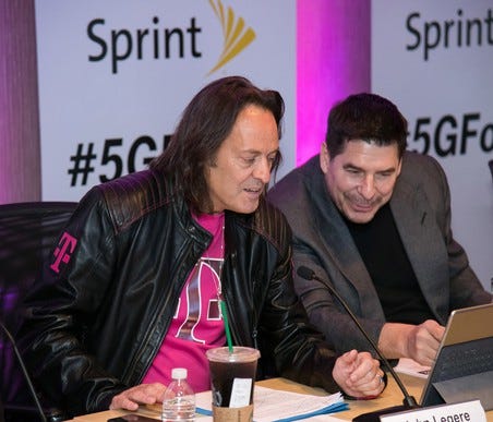T-Mobile CEO John Legere (left) and Sprint Executive Chairman Marcelo Claure are seen at the press conference to announce their companies' merger.
