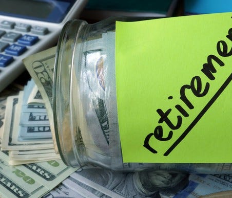 Glass jar with sticky note labeled Retirement holding cash, on a flat surface next to a calculator.