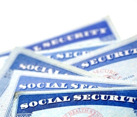 A small pile of Social Security cards messily stacked on each other.