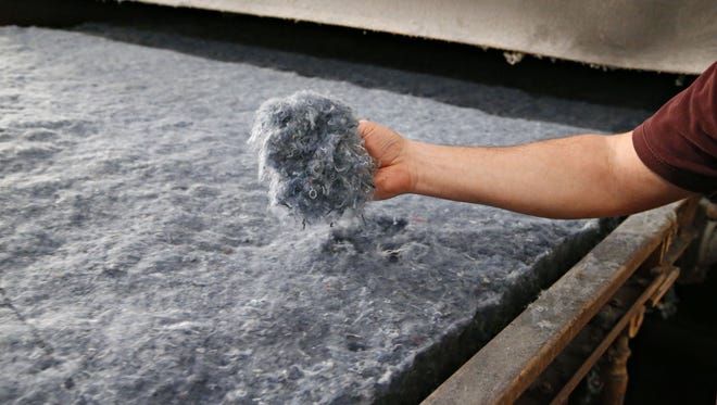 Recycled denim pulp, which at this point is the consistency of cotton candy that has been mixed with fire, mildew and mold retardants, as well as a heat activated bonding agent on a conveyor on its way to a 365 degree oven for forming into insulation batts at the Bonded Logic plant in Chandler on February 3, 2016.