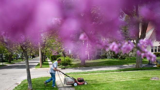 Bay City resident Rob Seifferly mows his daughter Megan's lawn on Monday, May 9, 2016 at her home on Elizabeth Street in East Lansing. Rob traveled from Bay City to help move his daughter out of the home. Megan recently graduated from Michigan State University.