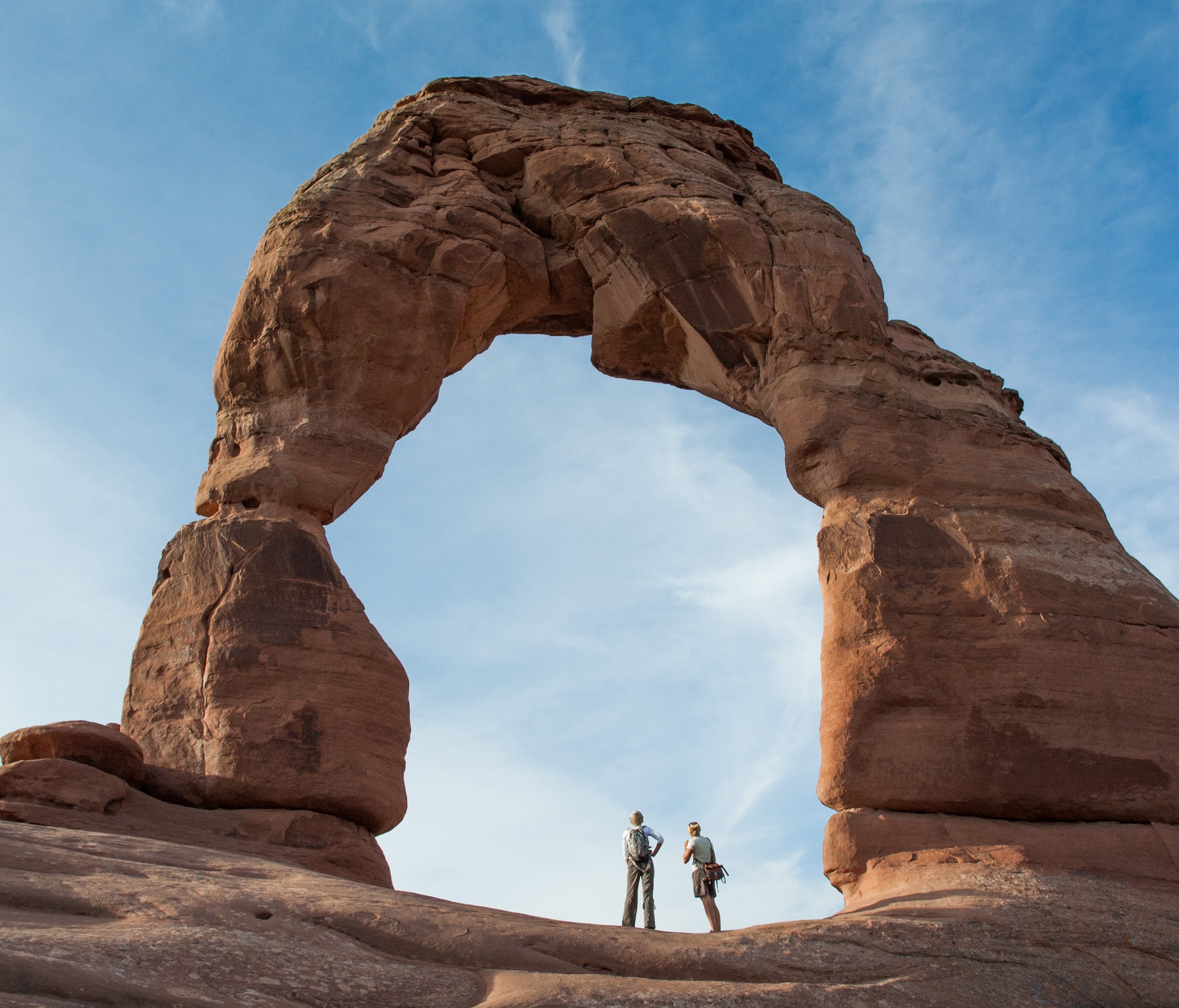 Hikers stand under Delicate Arch 2_VisitUtah