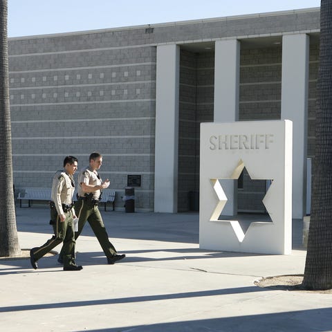 Two sheriff's deputies walk  past the Southwest De