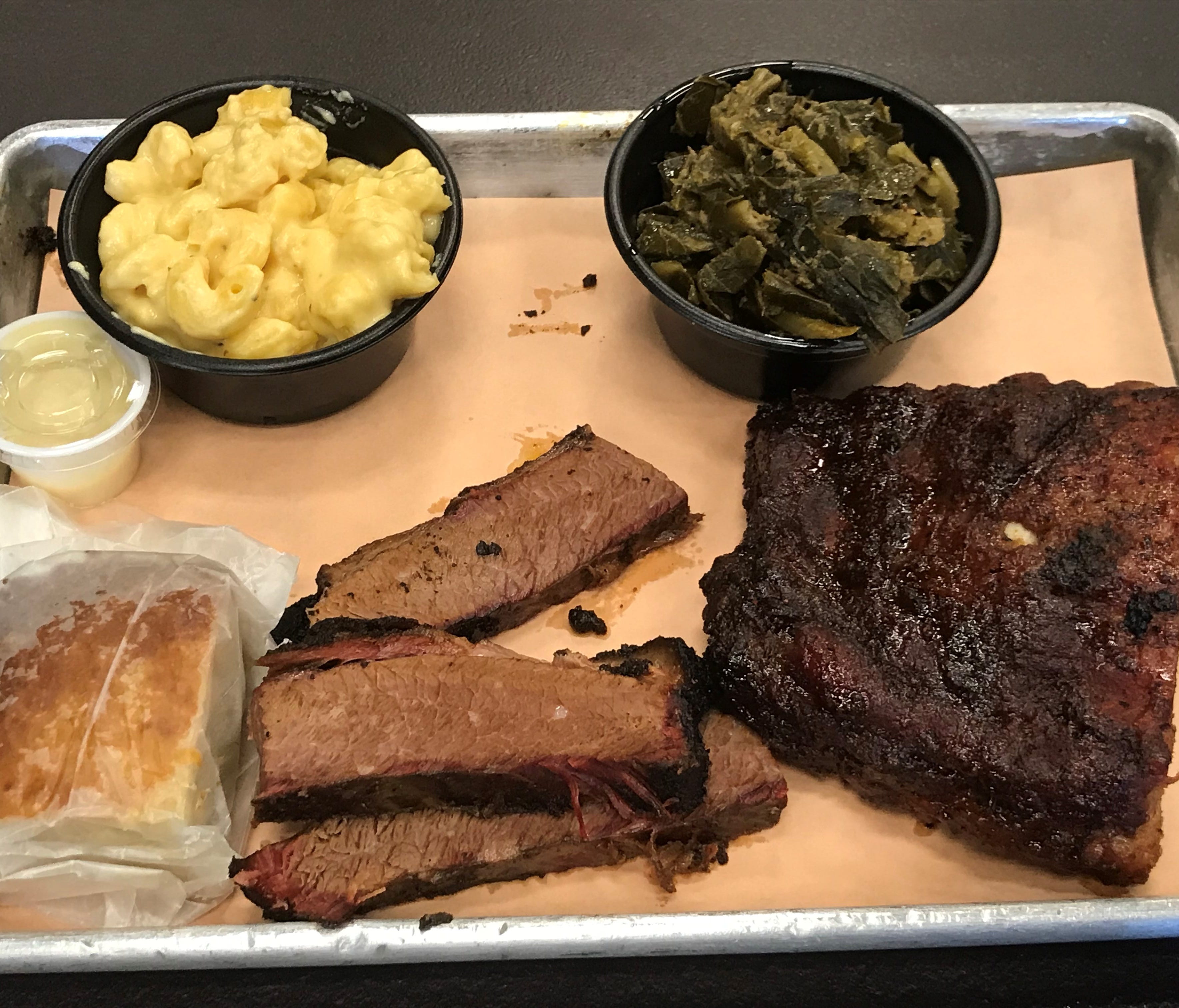 A two-meat platter combines baby back ribs, beef brisket, macaroni and cheese, collard greens and cornbread.