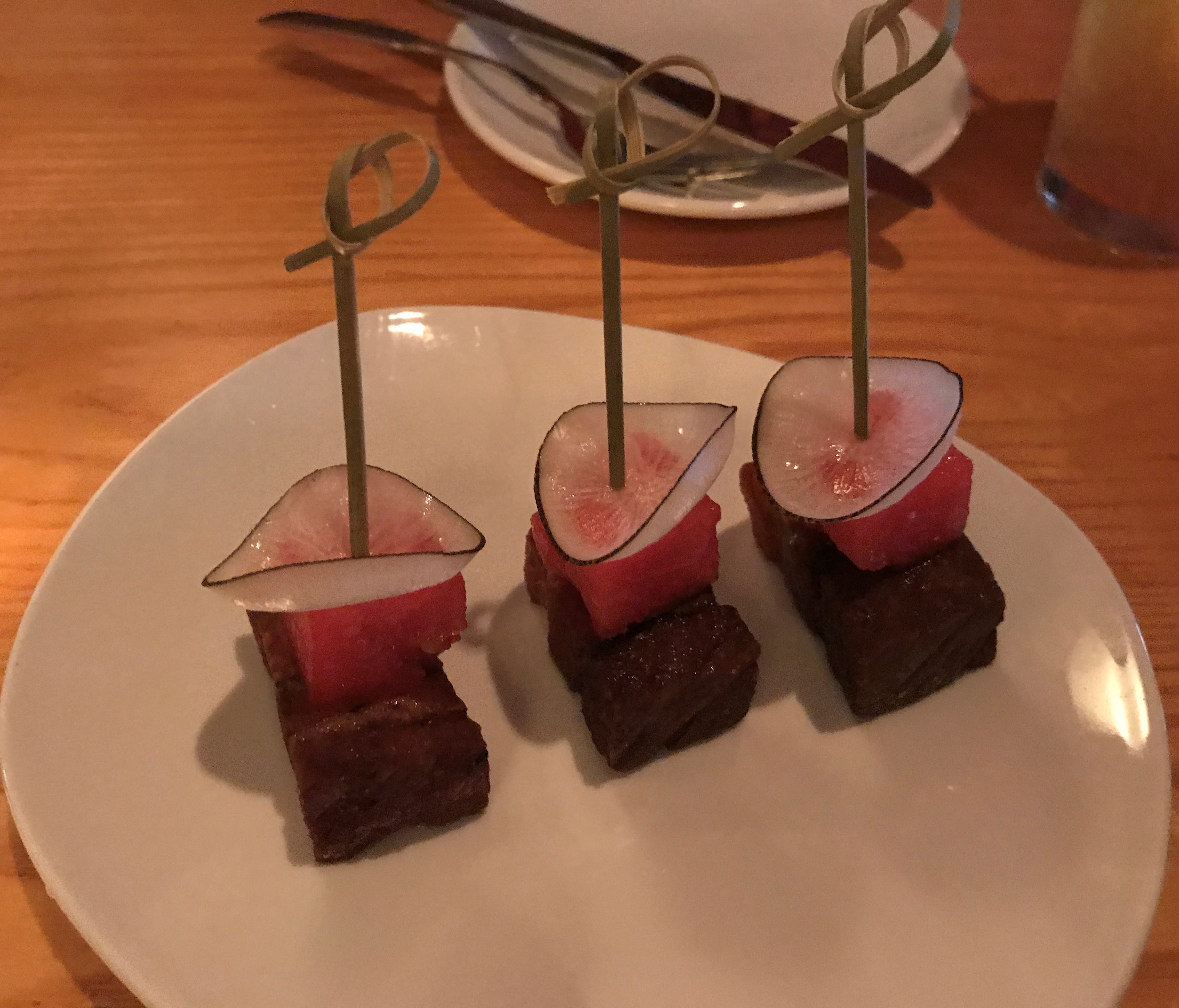 The signature dish is lacquered pork belly bites with radish and watermelon.