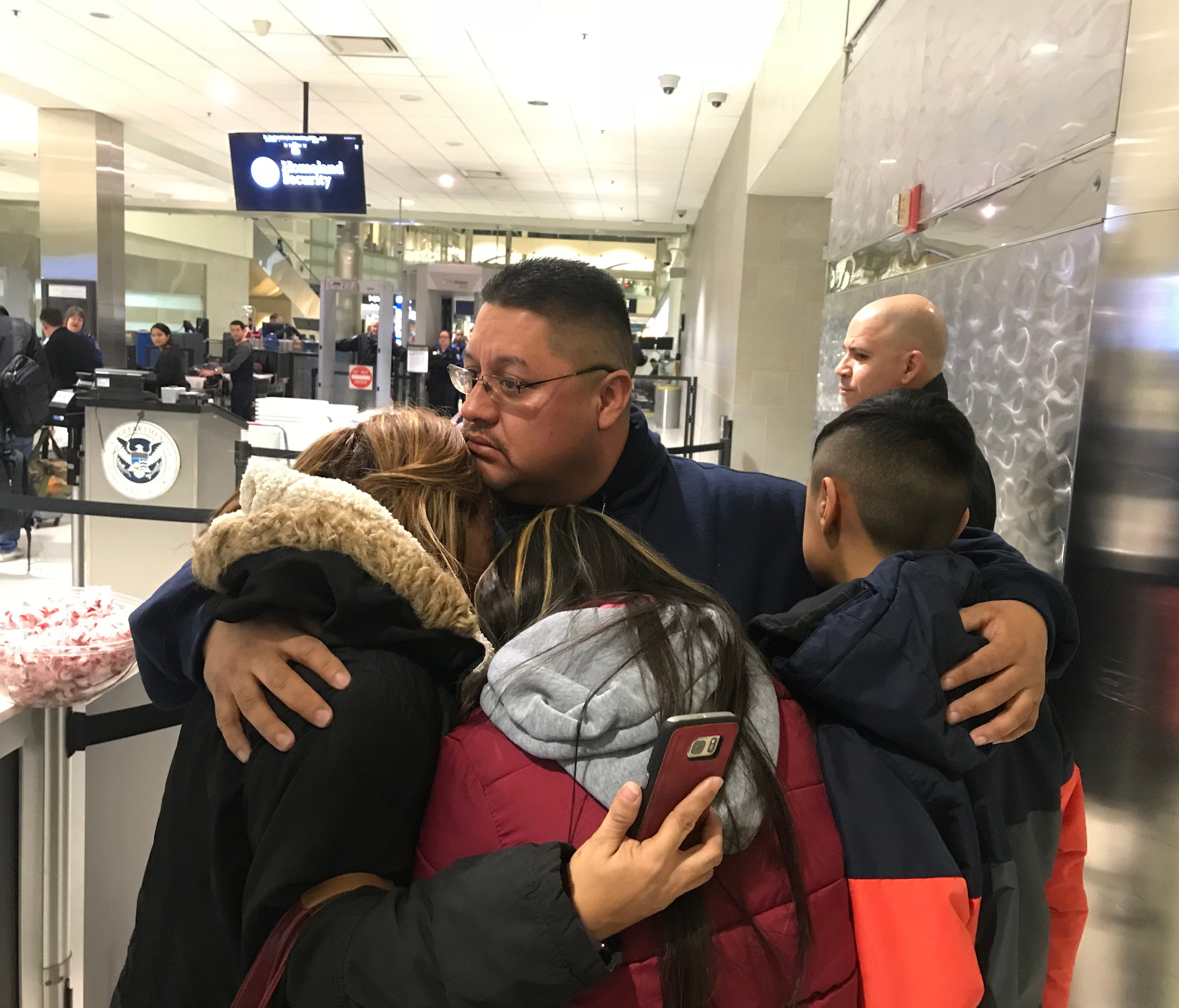 Jorge Garcia, 39, of Lincoln Park, hugs his wife, Cindy Garcia, and their two children at Detroit Metro Airport on Jan. 15, 2018, moments before boarding a flight to Mexico. He was ordered deported after living in the U.S. since he was 10 years old, 