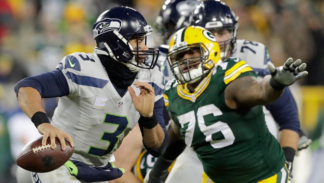 Seattle Seahawks quarterback Russell Wilson (3) scrambles away from Green Bay Packers defensive end Mike Daniels (76) in the fourth quarter.